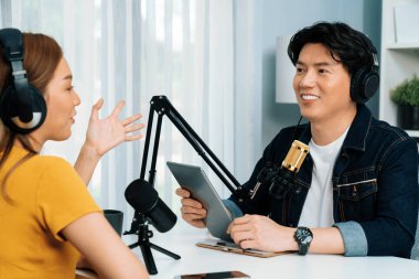 Gülümseyen radyo etkili sunucu elinde tablet, kulaklık takıyor kadın konuşmacı sosyal medya online canlı yayın kanalı ile röportaj yapıyor ve sabah stüdyo kaydında paylaşım linkini paylaşıyor. İnfobahn.