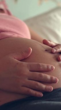 Hamile bir kadın çocuğuna bakarken kendini mutlu hissediyor. Hamile karnında bebek taşıyan hamile bir anne. Doğum öncesi bakım ve kadın hamileliği konsepti.