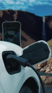 Elektrikli araba, doğal ortam, şelale ve akış arkaplanındaki şarj istasyonundan enerji yüklüyor. Yenilenebilir enerji kaynaklı EV otomobillerin enerji sürdürülebilirliği kavramı.