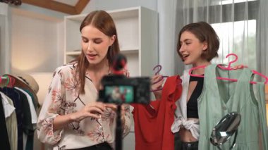 İki kadın nüfuzlu kişi canlı yayın yapan video klip eleştirisi kıyafetlerini sosyal medyada ya da blogda yayınlıyor. Stüdyo ışıklandırmalı mutlu genç kız çevrimiçi pazarlama oturumu yayını için..