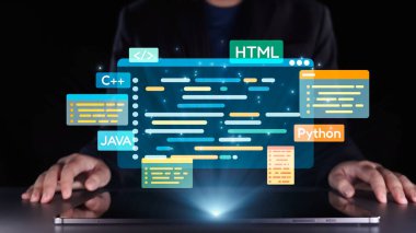 Bir programcı, karanlık bir ortamda bir dizüstü bilgisayarın üzerinde canlı dijital kod grafikleriyle etkileşime geçerek modern programlama dilleri ve teknolojik yenilikler sergiliyor. Dörtgen