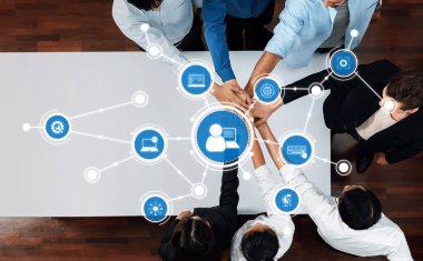 Çeşitli profesyonellerden oluşan bir grup, dijital bağlantı ve stratejik planlama yoluyla takım çalışması ve yenilikçi fikirleri vurgulayan çağdaş bir ofis ortamında işbirliği yapmaktadır. Dostluk