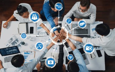 Üst düzey ofis çalışanları ofis odasında el ele tutuşarak iş sinerjisini ve iş yerindeki güçlü üretken takım çalışmasını sembolize ediyor. İş çalışanları arasındaki işbirliği ve birlik. İhtiyatlı Dostluk