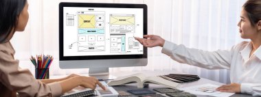 Masadaki bir grup iç mimar takımı dizüstü bilgisayarında mimari yazılım bulunan çeşitli ruh hali tahtası örneklerini seçiyor. Modern yenileme ve iç malzeme seçimi konsepti. İçgörü