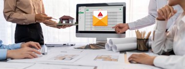 İç mimar tasarımcı grubu, daha kesin tasarım için planlar ve dizüstü bilgisayar ekran mimari yazılımı üzerinde birlikte tartışıyorlar. Modern ev tasarımı ve yenileme. İçgörü