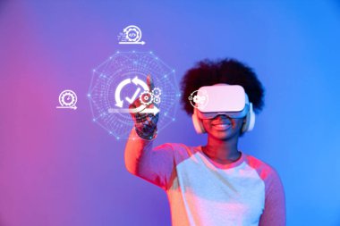 Sanal gerçeklik teçhizatı kullanan genç bir birey, çevik iş yöntemlerini temsil eden dijital elementlerle etkileşime geçerek, yenilik ve modern girişim uygulamalarındaki katılımı vurguluyor. XDMCP