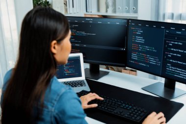 İnternet sitesi uygulamasının kodlama verileriyle birlikte online bilgi yazarak kot gömlek giyen genç Asyalı geliştirici. Güvenlik analizi ile çevrili iki ekran. Taktik.