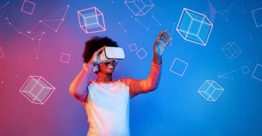 VR gözlüklü Afrikalı kız mavi ve pembe arka planda duruyor ve yüzen geometrik şekle bakıyor. Heyecanlı insan görsel gerçeklik dünyasına giriyor. Teknoloji yeniliği. Yaratıcılık.