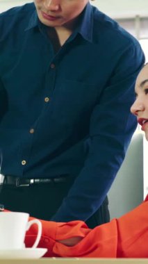 İki iş adamı toplantı odasında proje stratejisi hakkında konuşuyor. İş adamı, mali veri raporu hakkında sohbet ve tavsiyelerde bulunurken, modern işyerindeki iş arkadaşıyla proje planlamasını tartıştı.