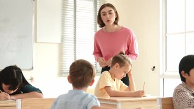 Enerjik zeki öğretmen sınıftaki beyaz çocuğa sınıf çalışmasını anlatırken aynı zamanda çok kültürlü bir öğrencinin derste dinlemesini ve çalışmasını anlatıyor. Aktif öğretmen sınav ya da sınıf çalışmasından bahsediyor. Pedagoji.