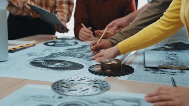 Dinamik bir ekip, modern bir iş yerindeki karmaşık mühendislik planları üzerine işbirlikçi bir beyin fırtınası yapıyor, proje geliştirmede yaratıcılık ve yenilik sergiliyor. SACTR