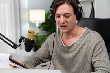 Akıllı yayıncının sunucu kanalı canlı sosyal medya yayını ile dinleyicilere senaryo okuyarak, kulaklık takarak modern ev stüdyosundaki video flamalarını kaydediyor. Bireysel.