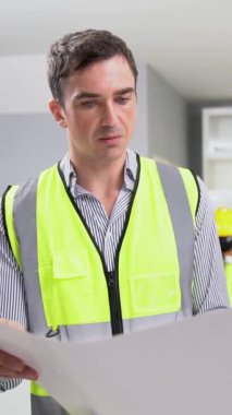 Competent investor investor discuss and brainstorm with engineer on blueprints, construction plans before putting them into action. Professional establishing investment plan for engineering projects.