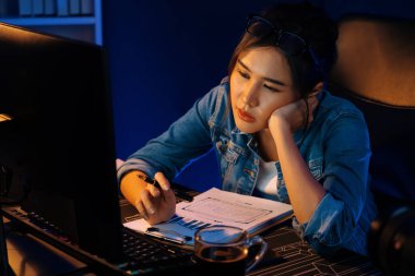 Bitkin düşmüş, genç, güzel Asyalı yaratıcı hisler, bilgisayardan e-posta beklemek için bekliyor. Projenin yaratıcısı sosyal medyanın veri tablosunu gece vakti neon ofiste karşılaştırıyoruz. Taktik.