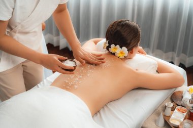 Lüks spa salonlarında sıcak mum ışığında cilt bakımı yaptıran kadın müşteri. Sağlık Spa vücut fırçasında tuz temizleme güzellik tedavisi. Sessiz.