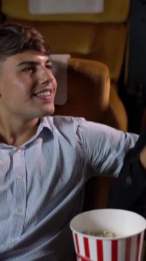 Erkekler ve kadınlar tiyatroda patlamış mısır yemek ve atmak eğlenceliydi.