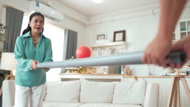 Büyükannenin elinde boru var ve göz, el koordinasyonunu geliştirmek ya da odaklanma ve konsantrasyonu arttırmak için top yuvarlama oyunu oynuyor. Yaşlı çift stresi azaltıyor. Sağlık hizmetleri. Myrmidon.