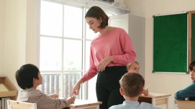 Sınıfta çeşitli çocuklar sınıf ödevlerini yaparken, Kafkasyalı öğretmen sınıfta yürüyor ve öğrenci ödevlerini kontrol ediyor. Çeşitli zeki öğrenciler ilkokulda ders veriyor ve not alıyor. Pedagoji.