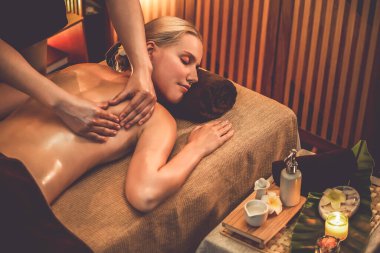 Beyaz kadın müşteri stres önleyici spa masajının keyfini çıkarıyor ve lüks otel ya da otelde sıcak mum ışığında güzellik teniyle eğleniyor. Sessiz.