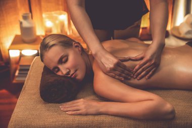Beyaz kadın müşteri stres önleyici spa masajının keyfini çıkarıyor ve lüks otel ya da otelde sıcak mum ışığında güzellik teniyle eğleniyor. Sessiz.