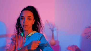 Çekici mutlu dansçı kameraya bakarken zeki kadın neon ışıkla kafiyeli hareket ediyor. Profesyonel İspanyol şarkıcı çeşitli arkadaşlarıyla renkli kıyafetler giyerken break dans yapıyor. Mutluluk.