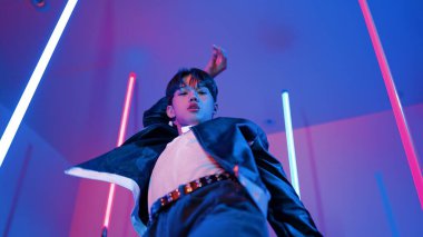 Profesyonel sokak dansçısının sıradan kıyafetlerle kameraya baktığı alçak açılı kamera. Stüdyoda mor ışık altında dururken şehirde pop müzik yapan yetenekli bir sanatçı. Kapatın. Mutluluk.