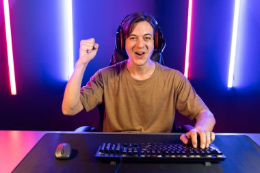 Kazanmak için çevrimiçi oyun oynayan akıllı flama makinesinin sunucu kanalı, neon ışıklı odada seçilen takım yarışması için izleyicilerle birlikte canlı yayında canlı yayında kulaklık takıyor. Bireysel.