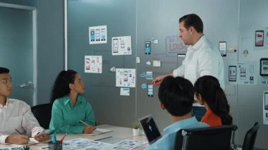 Bir grup profesyonel iş adamı Ux ve Ui tasarımı hakkında konuşuyor. İşbirlikçi çeşitli iş adamları pazarlama planı hakkında beyin fırtınası yapıyor. Birlikte çalışan iş adamları. Yönlendirici.