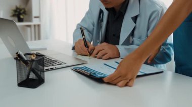 Hastane masasında birlikte çalışan ve tıbbi tedavi planlayan çeşitli profesyonel sağlık görevlileri. Takım çalışması başarılı hastalıklara ve hastalıklara yol açar. Ağır çekim. Katı.