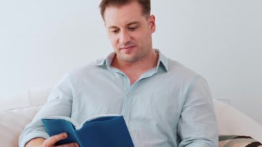 Kanepede oturan orta yaşlı bir adam, sosyal ve teknolojik mesleki gelişmeler hakkında ders kitabı okur ya da çocukları iyi bir yetişkin baba olmak için yetiştirir. Hayat boyu öğrenme konsepti. Uyumsuzluk.