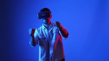 Sanal dünyada araba sürerken VR gözlük takan sıradan giysili profesyonel bir oyuncu. Erkek model yarış oyunu oynarken sanal gerçeklik kulaklığı kullanarak metadünyaya erişiyor. Aygıt.