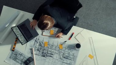 Planı ölçmek için cetvel ve ekipman kullanan inşaat mühendisinin en üst görüntüsü. Yapışkan notlar ve hesap makinesiyle bina inşaatı üzerinde çalışırken çalışan mimar. Hizalama.