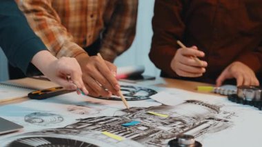 Mühendisler, tasarım araçları ve planlarıyla dolu bir çalışma alanında teknik çizimler, işbirliği ve yaratıcılığı elden ele inceler. SACTR