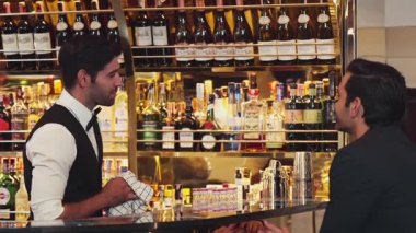 Güzel görünümlü barmen, buzlu soğuk bardakla müşteriye hoş geldin içkisi ikram ederek, büyüleyici profesyonelliğiyle ilk izlenimi sıcak bir şekilde karşıladı. Vinosity.