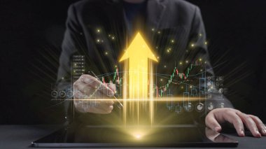 Bir iş adamı, parlayan bir ok ve detaylı grafiklerle birlikte iş analizindeki modern teknolojiyi gösteren finansal büyümeyi analiz etmek için bir tablet kullanır. Dörtgen