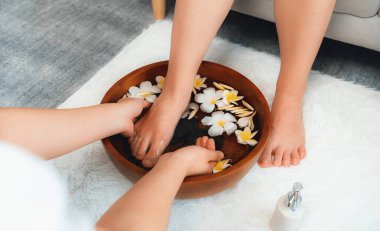 Kadınlar lüks spa salonlarında keyifli ayak masajlarına devam ederken, masör de hafif gün ışığı atmosferinde refleksoloji terapisi veya otel ayak spa 'sında. Sessiz.