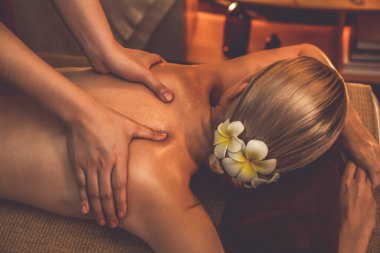 Yakından kadın müşteri strese karşı spa masajını rahatlatıyor ve lüks otel ya da otelde sıcak mum ışığında güzellik teniyle eğleniyor. Sessiz.