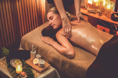Beyaz kadın müşteri stres önleyici spa masajının keyfini çıkarıyor ve lüks otel ya da otelde sıcak mum ışığında güzellik teniyle eğleniyor. Sessiz.
