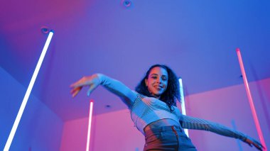 Latin dansçıların kameraya bakıp şehrin pop müziğiyle dans ettiği düşük açılı kamera. Profesyonel çekici hipster, mor veya neon ışıklı hip hop şarkısına geçiyor. Şık bir kumaş. Mutluluk.