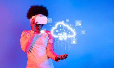 Genç bir insan, dijital depolama çözümlerindeki modern yenilikleri sembolize ederek, bulut hesaplama grafikleriyle etkileşim halinde iken sanal gerçeklik teknolojisiyle neşeyle meşgul oluyor. XDMCP