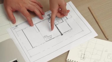 Akıllı mimar ve akıllı mühendisin dizüstü bilgisayarlı videosu mimarlık bürosundaki inşaat isabet planı hakkında tartışıyorlar. Eline odaklan. - Yakın çekim. Tanımlama.