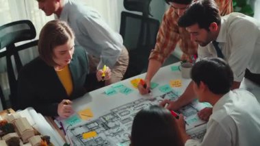 Proje planıyla masaya otururken bir grup farklı takım planlama stratejisi. Zeki iş adamlarının beyin fırtınası ve ev yapımı için birlikte çalıştıklarının en üst düzey görüntüsü. Hizalama.