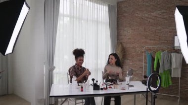 İki kadın nüfuzlu kişi canlı yayında video görüntülerini çekiyor. Makyaj çok önemli sosyal medya veya blog. Kozmetik stüdyosu ışıklandırmalı mutlu genç kız çevrimiçi pazarlama oturumu yayını için..