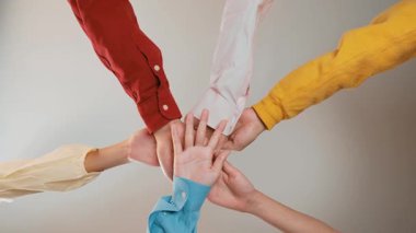 Panoramik video mutlu Asyalı şirket çalışanı rengarenk günlük giysiler içinde yan yana oturup el ele tutuşarak sembol uyum takımını, pozitif çevre işyerini yükseltiyor. Sinerjik