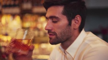 Beyaz gömlekli, eski moda kokteyl içen zeki bir adamın profili. Cuma gecesi lüks tezgah gece kulübünde yapılan toplantıda özel parti içeceklerinin olduğu bir kameraya bakıyor. Vinosity.