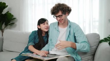 Komik liseli kız masal kitabına işaret ederken mutlu bir baba hikâyesi ve dokunaklı bir jest. Öğrenciler ebeveyn ararken peri kuyruğu hakkında konuşmaktan zevk alırlar. Aile eğlence konsepti. Pedagoji.