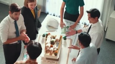 Ekibin el ele tutuşmasını ve toplantı masasında planı ve mimari modelle tezahürat ve cesaret verici bir ekip oluşturmasını yukarıdan aşağıya izleyeceğiz. Müdür alkışları başarılı projeye. Hizalama.