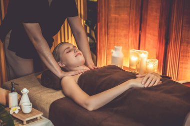 Beyaz kadın müşteri stres önleyici spa masajının keyfini çıkarıyor ve lüks otel ya da otelde sıcak mum ışığında güzellik teniyle eğleniyor. Sessiz.