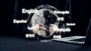 Modern bir çalışma alanında küresel iletişim ve çeşitliliği temsil eden, çeşitli dillerle çevrelenmiş, el ele tutuşan, dünyayı gösteren dijital bir tasvir. Dörtgen