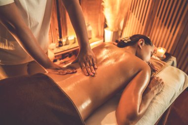 Beyaz kadın müşteri stres önleyici spa masajının keyfini çıkarıyor ve lüks otel ya da otelde sıcak mum ışığında güzellik teniyle eğleniyor. Sessiz.